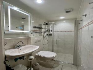 a bathroom with a toilet and a sink and a shower at Bungalow in Sint Maartenszee near beach in Sint Maartenszee