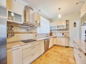 une cuisine avec des armoires blanches et un plancher en bois dans l'établissement Holiday Home in winouj cie near Baltic Beach, à Świnoujście