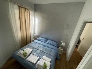 ein Schlafzimmer mit einem blauen Bett mit Handtüchern darauf in der Unterkunft Pop House in Rapallo