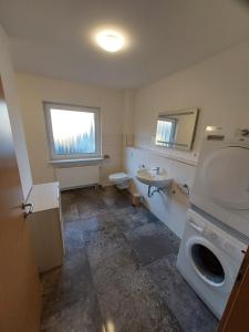 a bathroom with a sink and a toilet and a window at Ferienhaus Auenland in Brunsbüttel +9 photos