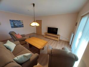 a living room with a couch and a table at Ferienhaus Auenland in Brunsbüttel