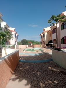 a courtyard with a pool inbetween two buildings at Holiday Maio in Calheta Do Maio