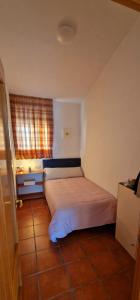 ein kleines Schlafzimmer mit einem Bett in einem Zimmer in der Unterkunft Casa en El Pedroso de tres habitaciones in El Pedroso