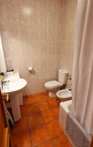 ein Badezimmer mit Toilette und Waschbecken in der Unterkunft Casa en El Pedroso de tres habitaciones in El Pedroso + 7 Fotos