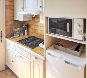 a kitchen with a microwave and a stove in it at Maison charmante à Vaux-sur-Mer avec jardin clôturé in Vaux-sur-Mer