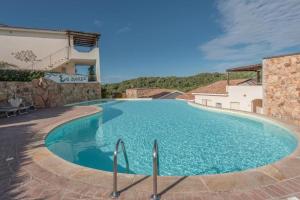 a large swimming pool with blue water at Ea Bianca Vibes in Arzachena