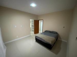 a bedroom with a bed in a white room at Casa Refúgio do Vale *Unimed* in Volta Redonda