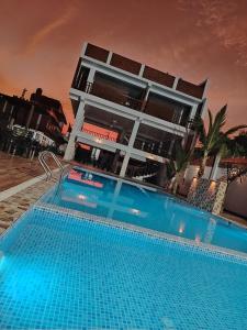 a hotel with a swimming pool in front of a building at Oliver's Garden Country Hotel in Chincha