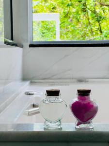 two glass vases sitting on a counter next to a sink at Casa com banheira in Governador Celso Ramos