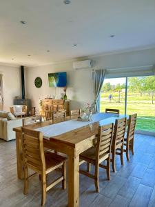 a dining room with a large wooden table and chairs at Puesta de Sol Casa Quinta in Azul