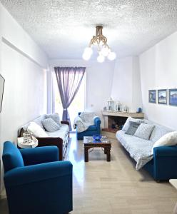 a living room with blue chairs and a couch at Gentle Breeze apartment in Kamena Vourla