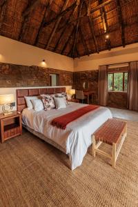 阿马卡拉保护区Induli Lodge - Amakhala Game Reserve的带一张大床和木质天花板的卧室 更多27张照片