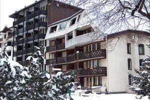 ein großes Apartmenthaus mit Schnee davor in der Unterkunft Le Balcon du Brévent - Happy Rentals in Chamonix-Mont-Blanc + 15 Fotos