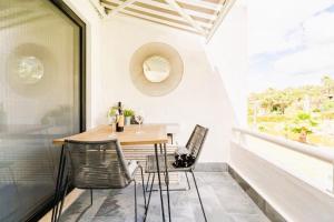 un tavolo e delle sedie su un balcone con una finestra di Scarlet's Place - 1 bed Victory Village Quinta Do Lago - beach, nature, lakes a Quinta do Lago