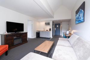 a living room with a couch and a flat screen tv at Adara Hotel in Whistler