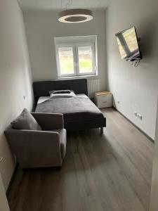a bedroom with a bed and a couch in it at Ruhige Wohnung mit S-Bahn Bindung in Altomünster