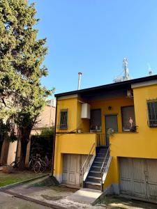 a yellow house with stairs and a tree at Gionas - Casa indipendente in zona strategica in Milan