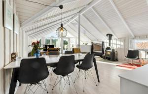 BrøndstrupにあるGorgeous Home In Grenaa With Wifiのダイニングルーム(テーブル、黒い椅子付)