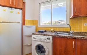 a kitchen with a washing machine and a sink at Cozy Apartment In Torrox Costa in Torrox Costa