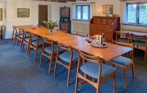 a large wooden table with chairs and wine glasses at 7 Bedroom Awesome Home In Ørum Djurs in Fjerupgårde