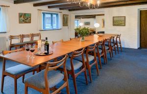 a long wooden table with chairs and wine glasses at 7 Bedroom Awesome Home In Ørum Djurs in Fjerupgårde