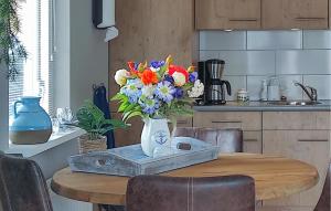 a table with a vase of flowers on top of it at 2 Bedroom Awesome Home In Callantsoog in Callantsoog