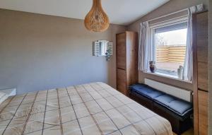 a bedroom with a bed and a window at 2 Bedroom Awesome Home In Callantsoog in Callantsoog +2 photos