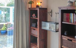 a wooden book shelf with a fish tank in a room at 2 Bedroom Awesome Home In Callantsoog in Callantsoog
