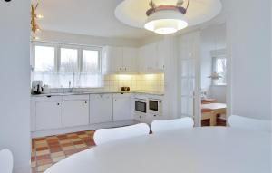 a kitchen with white cabinets and a table and chairs at Nice Home In Humble With Sauna in Humble