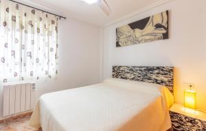 ein weißes Schlafzimmer mit einem Bett und einem Fenster in der Unterkunft Beautiful Home In Pilar De La Horadada in Pilar de la Horadada