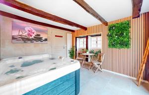 a bath tub in a room with a table at 3 Bedroom Lovely Home In La Douze in La Douze +22 photos