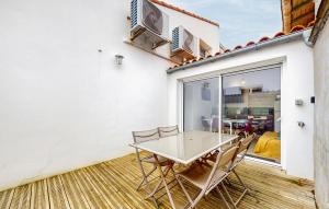 ein Esszimmer mit Tisch und Stühlen auf einer Terrasse in der Unterkunft Gorgeous Home In Royan With Wifi in Royan