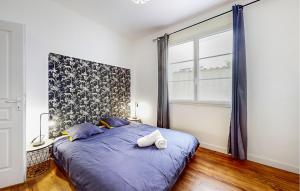 ein Schlafzimmer mit einem blauen Bett und einem Fenster in der Unterkunft Gorgeous Home In Royan With Wifi in Royan