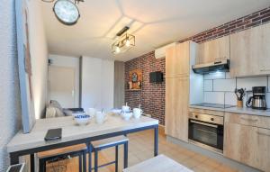 a kitchen with a table with a clock on the wall at Lovely Apartment In Fréjus With Wifi in Fréjus