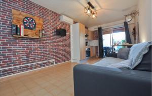 a living room with a brick wall and a couch at Lovely Apartment In Fréjus With Wifi in Fréjus