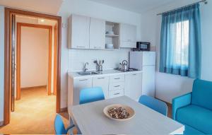 eine Küche mit einem Tisch und blauen Stühlen in einem Zimmer in der Unterkunft 1 Bedroom Cozy Home In Marina Di Modica in Marina di Modica