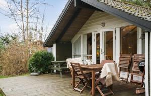 a wooden deck with a table and chairs on a house at Gorgeous Home In Gedser With Sauna in Gedser