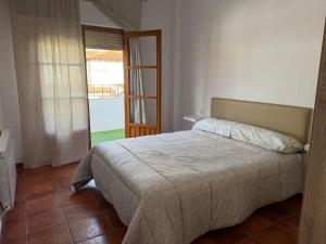 a bedroom with a bed and a door to a balcony at Cantarranas in Los Hinojosos