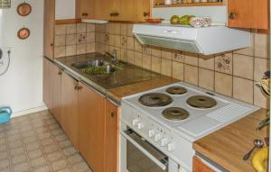a kitchen with a stove and a sink at 3 Bedroom Lovely Home In Valdemarsvik in Valdemarsvik