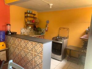 a kitchen with a counter and a stove in it at Suítes Vila do Surf , a original , desde 2010 in Ubatuba
