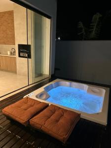 JuatubaRefúgio com Spa Jacuzzi 40 min BH的浴室内设有一个大型按摩浴缸和长凳