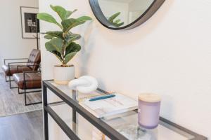 a glass table with a plant and a mirror at Plano 40 miles to Fifa Stadium Private Pool Lux Home by Vacation Your Way in Plano
