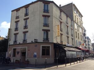 a building on the corner of a street at Hotel De La Place in Malakoff