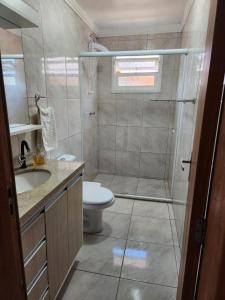 ein Badezimmer mit Dusche, Toilette und Waschbecken in der Unterkunft Casa temporada em Xangri-Lá in Xangri-lá
