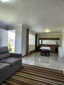 ein Wohnzimmer mit Sofa und Tisch in der Unterkunft Casa temporada em Xangri-Lá in Xangri-lá