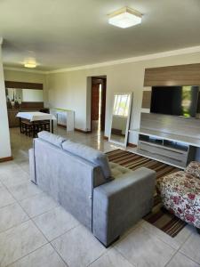 ein Wohnzimmer mit Couch und Flachbildfernseher in der Unterkunft Casa temporada em Xangri-Lá in Xangri-lá