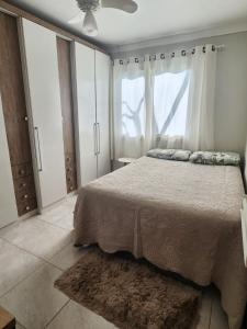 ein Schlafzimmer mit großem Bett und Fenster in der Unterkunft Casa temporada em Xangri-Lá in Xangri-lá + 26 Fotos