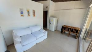 a living room with a white couch and a refrigerator at Apart Costanera II in Posadas