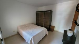 a bedroom with a white bed and a black cabinet at Apart Costanera II in Posadas +4 photos