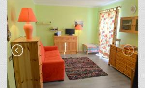 un salon avec un canapé orange et une chambre dans l'établissement House La Motta, à Borgata Sestriere